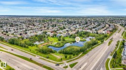 Neighborhood with extensive residential development, surrounding a natural pond feature with established greenery - 