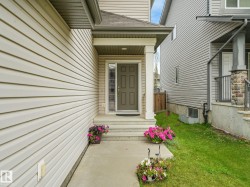 Covered entryway featuring a solid-panel door with decorative glass inserts - 
