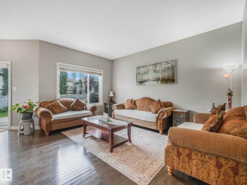 Wood-finish flooring, neutral wall tones, and expansive windows - 1478 37B Avenue Nw, Edmonton, AB - Indoor Photo Showing Living Room