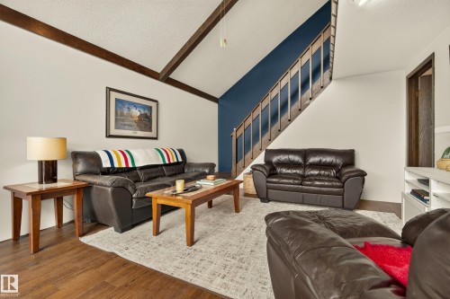 Vaulted ceilings with exposed wood beams, wood-finish flooring, and a built-in staircase - 264 Beach Avenue, Rural Barrhead County, AB - Indoor Photo Showing Living Room