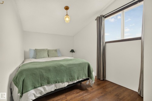 Wood-finish flooring, white walls, and a window with a dark frame - 264 Beach Avenue, Rural Barrhead County, AB - Indoor Photo Showing Bedroom