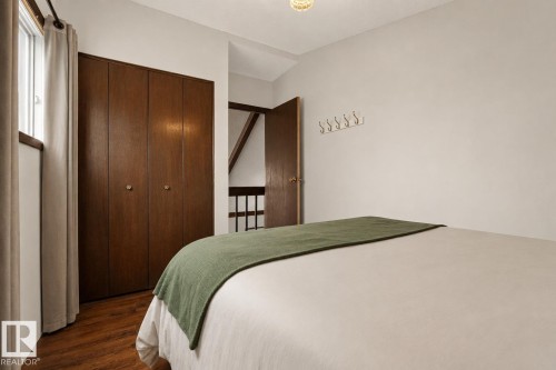 Wood-finish flooring with a multi-panel closet, a single window, and a built-in wall rack - 264 Beach Avenue, Rural Barrhead County, AB - Indoor Photo Showing Bedroom