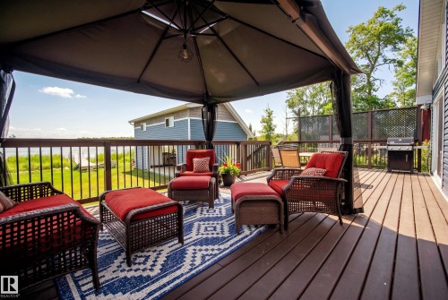 Expansive outdoor deck featuring wood-finish flooring, a gazebo, and a dark metal railing - 264 Beach Avenue, Rural Barrhead County, AB - Outdoor With Deck Patio Veranda With Exterior
