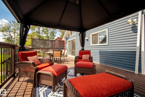 Expansive wood-finish deck with a dark-framed gazebo - 264 Beach Avenue, Rural Barrhead County, AB - Outdoor With Deck Patio Veranda With Exterior