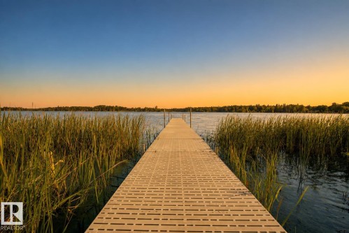 Waterfront access featuring a pier and natural aquatic vegetation - 264 Beach Avenue, Rural Barrhead County, AB - Outdoor With Body Of Water With View