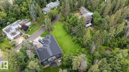 Aerial perspective showcasing a large residential lot with extensive tree coverage and a manicured lawn area - 2 Grandin Place, St. Albert, AB 