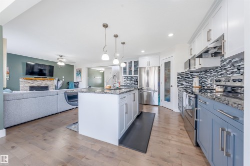 Kitchen featuring a central island with pendant lighting, stainless steel appliances, granite countertops, and a tiled backsplash - 76 Dunlop Wynd, Leduc, AB - Indoor Photo Showing Kitchen With Stainless Steel Kitchen With Upgraded Kitchen
