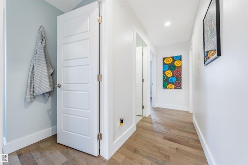 Wood-finish flooring throughout, white paneled doors, recessed lighting, and light-toned walls - 76 Dunlop Wynd, Leduc, AB - Indoor Photo Showing Other Room