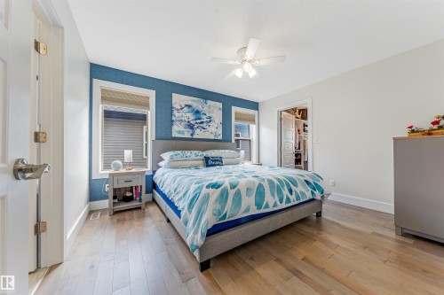 Light wood-finish flooring, white trim, and a ceiling fan with integrated lighting - 76 Dunlop Wynd, Leduc, AB - Indoor Photo Showing Bedroom