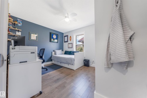 Hardwood-finish flooring, accent wall, ceiling fan, and a single window offering natural light - 76 Dunlop Wynd, Leduc, AB - Indoor Photo Showing Bedroom
