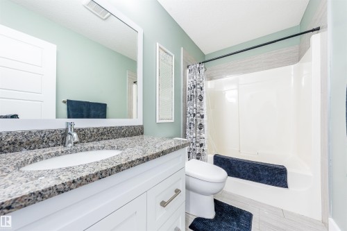 Vanity with a granite-style countertop and integrated sink - 76 Dunlop Wynd, Leduc, AB - Indoor Photo Showing Bathroom