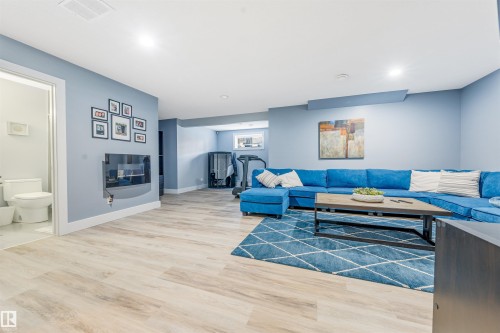 Light wood-finish flooring with a white trim throughout - 76 Dunlop Wynd, Leduc, AB - Indoor Photo Showing Living Room With Fireplace