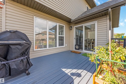 Spacious outdoor deck with blue-gray finish, sliding glass door access, and a multi-pane window - 76 Dunlop Wynd, Leduc, AB - Outdoor With Deck Patio Veranda With Exterior