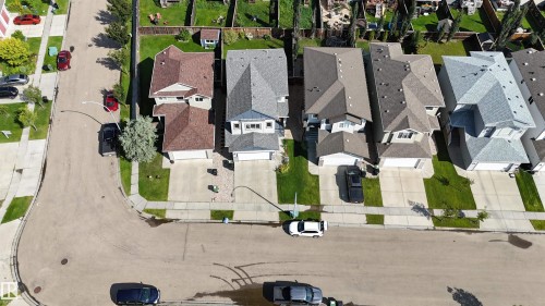 Residential neighborhood with paved streets and sidewalks, featuring multiple detached homes with various roof colors - 76 Dunlop Wynd, Leduc, AB - Outdoor With View