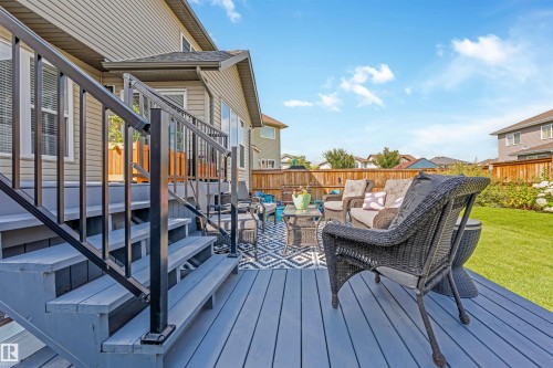Multi-level deck with gray finish and black metal railings, featuring a spacious grass lawn and a wood fence - 76 Dunlop Wynd, Leduc, AB - Outdoor With Deck Patio Veranda With Exterior