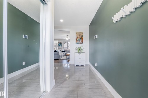 Hallway with light gray tile flooring, recessed lighting, and a mirrored closet door - 76 Dunlop Wynd, Leduc, AB - Indoor Photo Showing Other Room