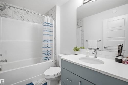 Bathroom featuring a single vanity with a light blue cabinet, white countertop, and an integrated sink - 3877 Chrustawka Place Sw, Edmonton, AB - Indoor Photo Showing Bathroom
