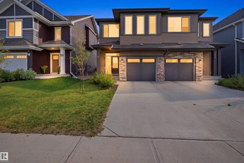 Contemporary exterior with stone facade accents and a two-car garage - 3877 Chrustawka Place Sw, Edmonton, AB - Outdoor With Facade