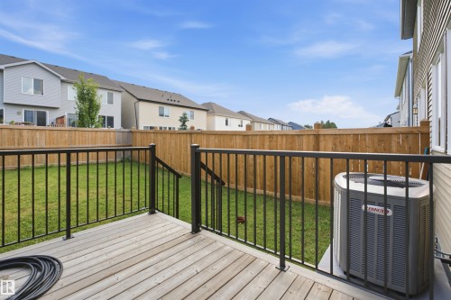 Upper-level wood-finish deck with black metal railings - 3877 Chrustawka Place Sw, Edmonton, AB - Outdoor With Deck Patio Veranda With Exterior