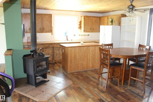 Wood-finish flooring throughout, complemented by a wood ceiling and a wood-paneled kitchen island - 49480 Rge Rd 41, Rural Leduc County, AB - Indoor