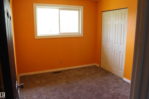 Carpeted flooring, white trim, a double-panel window, and bi-fold closet doors - 49480 Rge Rd 41, Rural Leduc County, AB - Indoor Photo Showing Other Room