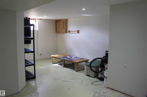 Recessed lighting, painted concrete flooring, and a wall-mounted wood-finish cabinet - 49480 Rge Rd 41, Rural Leduc County, AB - Indoor Photo Showing Other Room