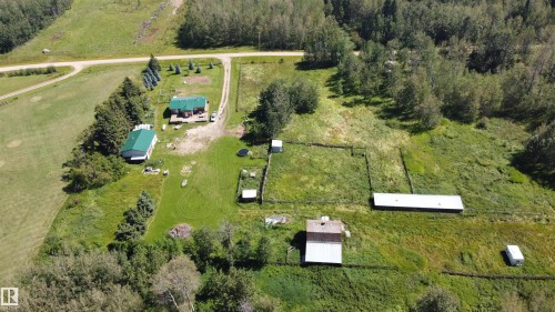 Single-story residence with a green metal roof, a secondary structure with a green metal roof, a third structure with a light-colored metal roof, and a fourth structure with a brown shingle roof - 49480 Rge Rd 41, Rural Leduc County, AB - Outdoor With View
