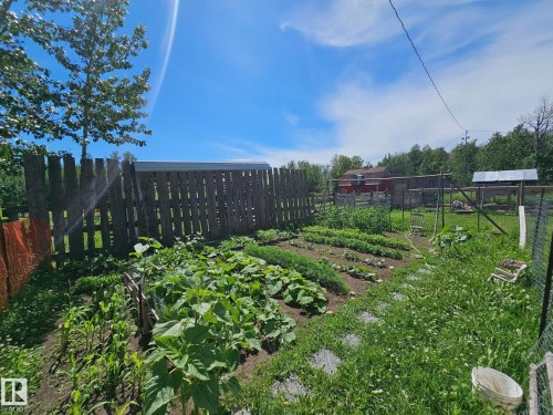 Expansive garden area featuring cultivated plots, a wood fence, and stepping stones - 49480 Rge Rd 41, Rural Leduc County, AB - Outdoor