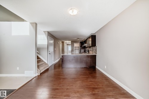 Open-concept living space featuring wood-finish flooring and light gray painted walls - 12118 125 Street Nw, Edmonton, AB - Indoor Photo Showing Other Room