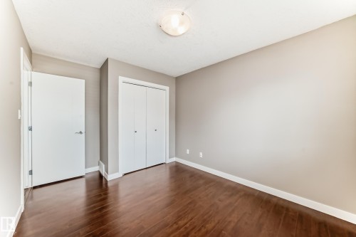 Spacious room featuring rich wood-finish flooring, neutral wall tones, and white trim - 12118 125 Street Nw, Edmonton, AB - Indoor Photo Showing Other Room