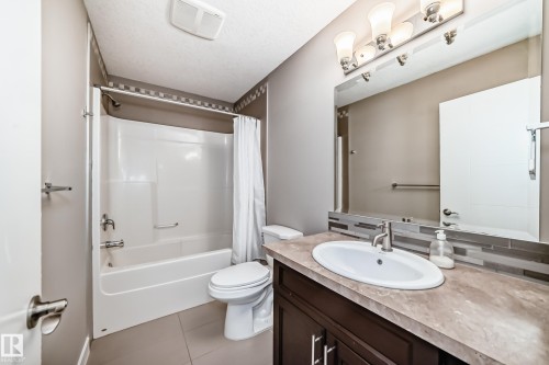 Bathroom featuring a shower-tub combination with white surround, a toilet, and a vanity with an oval sink - 12118 125 Street Nw, Edmonton, AB - Indoor Photo Showing Bathroom