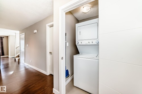 Dedicated laundry closet featuring a stacked washer and dryer unit - 12118 125 Street Nw, Edmonton, AB - Indoor Photo Showing Laundry Room