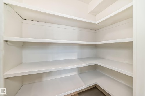 Walk-in pantry featuring expansive white shelving and dark tile flooring - 12118 125 Street Nw, Edmonton, AB - Indoor With Storage