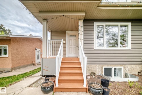 Inviting entryway with wide wood steps and white railings - 12118 125 Street Nw, Edmonton, AB - Outdoor With Exterior