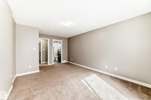 Carpeted room featuring light gray walls, white baseboards, and a flush mount ceiling light fixture - 12118 125 Street Nw, Edmonton, AB - Indoor Photo Showing Other Room