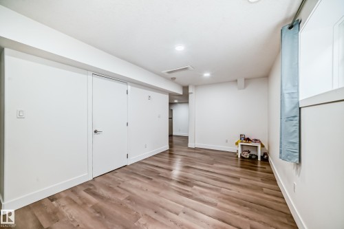 Spacious room featuring wood-finish flooring, recessed lighting, white walls, and a window for natural light - 12118 125 Street Nw, Edmonton, AB - Indoor Photo Showing Other Room