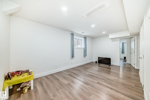 Spacious interior room featuring wood-finish flooring, recessed lighting, and white walls - 12118 125 Street Nw, Edmonton, AB - Indoor Photo Showing Other Room