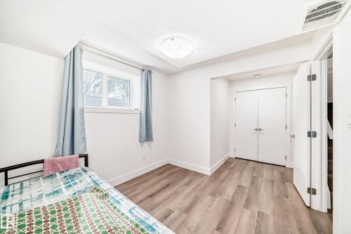 Bright room featuring light wood-finish flooring, white walls, and a ceiling light fixture - 12118 125 Street Nw, Edmonton, AB - Indoor Photo Showing Bedroom