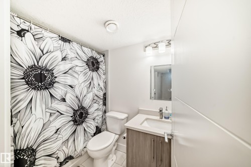 Contemporary bathroom featuring a single-sink vanity with wood-finish cabinetry, a rectangular basin, and a chrome faucet - 12118 125 Street Nw, Edmonton, AB - Indoor Photo Showing Bathroom