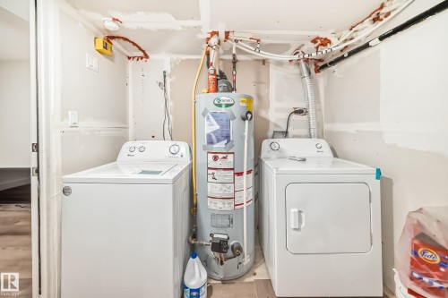 Dedicated laundry area featuring a water heater, washing machine, and dryer - 12118 125 Street Nw, Edmonton, AB - Indoor Photo Showing Laundry Room