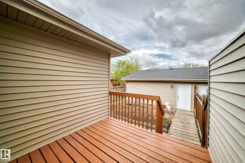 Wood-finish deck with a matching railing, complemented by beige horizontal siding - 12118 125 Street Nw, Edmonton, AB - Outdoor With Deck Patio Veranda With Exterior