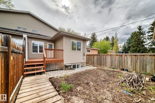 Private backyard featuring a wood deck with railing and stairs, a wood plank pathway, and a perimeter wood fence - 12118 125 Street Nw, Edmonton, AB - Outdoor With Deck Patio Veranda