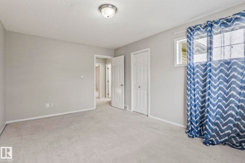 Light gray wall paint, textured ceiling, flush mount ceiling light fixture, white trim, and light-colored carpeting - #80 4350 23St Nw, Edmonton, AB - Indoor Photo Showing Other Room