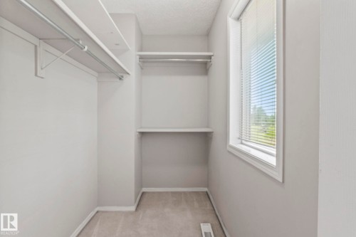 Integrated shelving and hanging rods - #80 4350 23St Nw, Edmonton, AB - Indoor With Storage