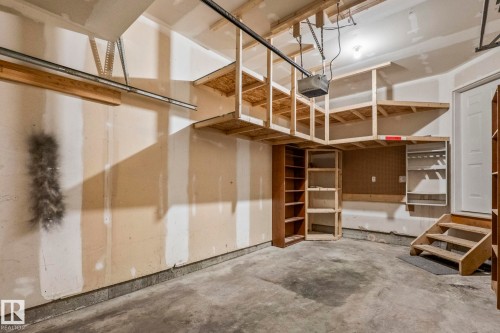 Garage featuring concrete flooring, built-in wooden shelving, and an overhead storage system - #80 4350 23St Nw, Edmonton, AB - Indoor Photo Showing Garage