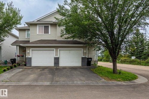 Two-story residence with siding exterior, dual garage doors, and a concrete driveway - #80 4350 23St Nw, Edmonton, AB - Outdoor With Facade