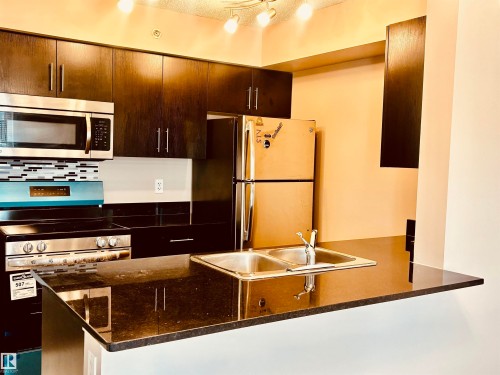 features s/s appliances and granite countertops - #409 12035 22 Av Sw, Edmonton, AB - Indoor Photo Showing Kitchen With Stainless Steel Kitchen With Double Sink