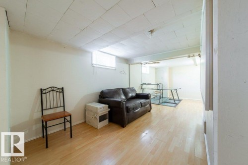 Wood-finish flooring with neutral wall paint and a drop ceiling - 7812 128 Avenue Nw, Edmonton, AB - Indoor