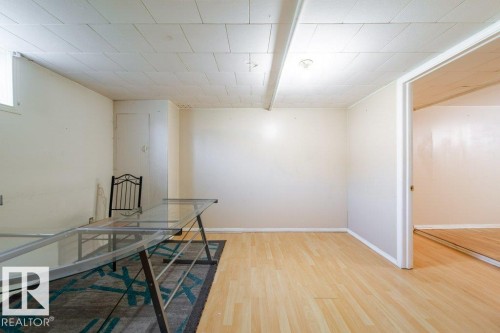 Light wood-finish flooring, white walls, and a recessed ceiling light - 7812 128 Avenue Nw, Edmonton, AB - Indoor Photo Showing Other Room