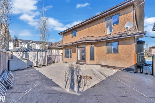 Rear stucco exterior with multiple windows and a double door entry - 10915 175 Avenue Nw, Edmonton, AB - Outdoor With Exterior